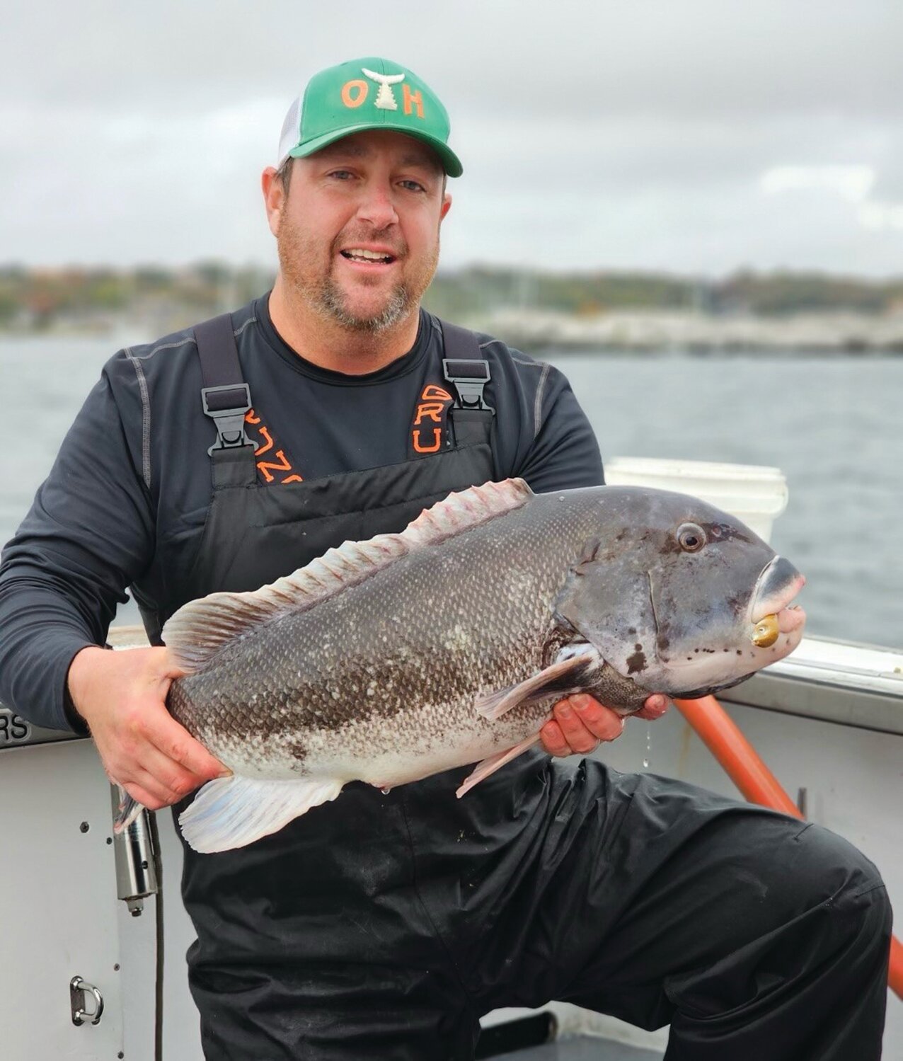 TAUTOG BITE: Chris “Higgie” Higgins with the 13.56-pound tautog he caught this week off Newport with Capt. Mike Littlefield of ArchAngel Charters. (Submitted photo)